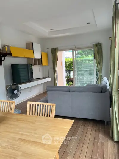 Modern living room with stylish furniture and large window view.