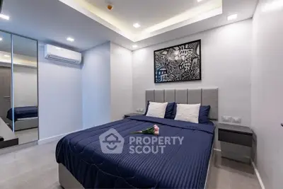 Modern bedroom with stylish decor and cozy ambiance, featuring a comfortable bed and contemporary artwork.