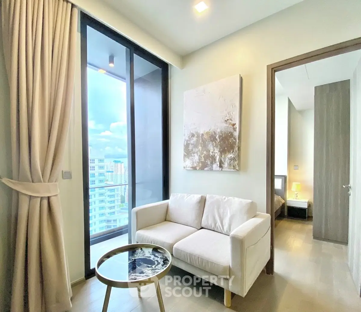 Modern living room with elegant decor and city view, featuring a cozy sofa and stylish coffee table.