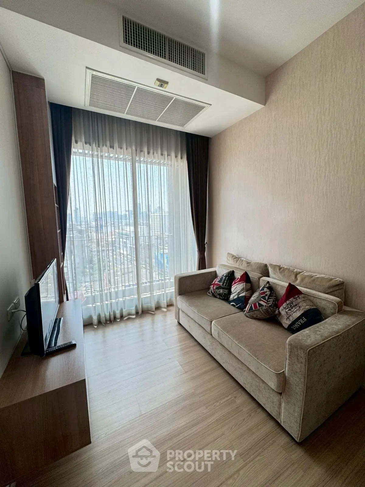 Modern living room with cozy sofa and large window offering city view