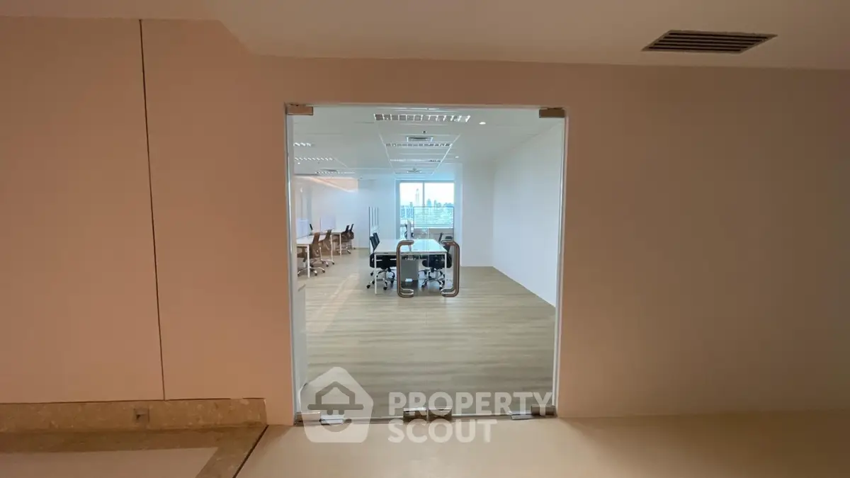 Modern office space with glass doors and city view, ideal for professional work environment.