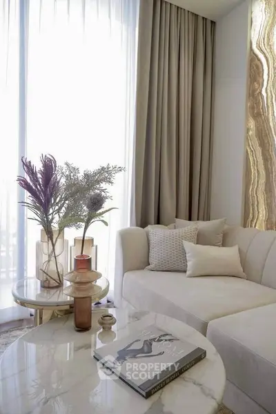 Luxurious living room with elegant decor, plush sofa, and natural light through large windows.