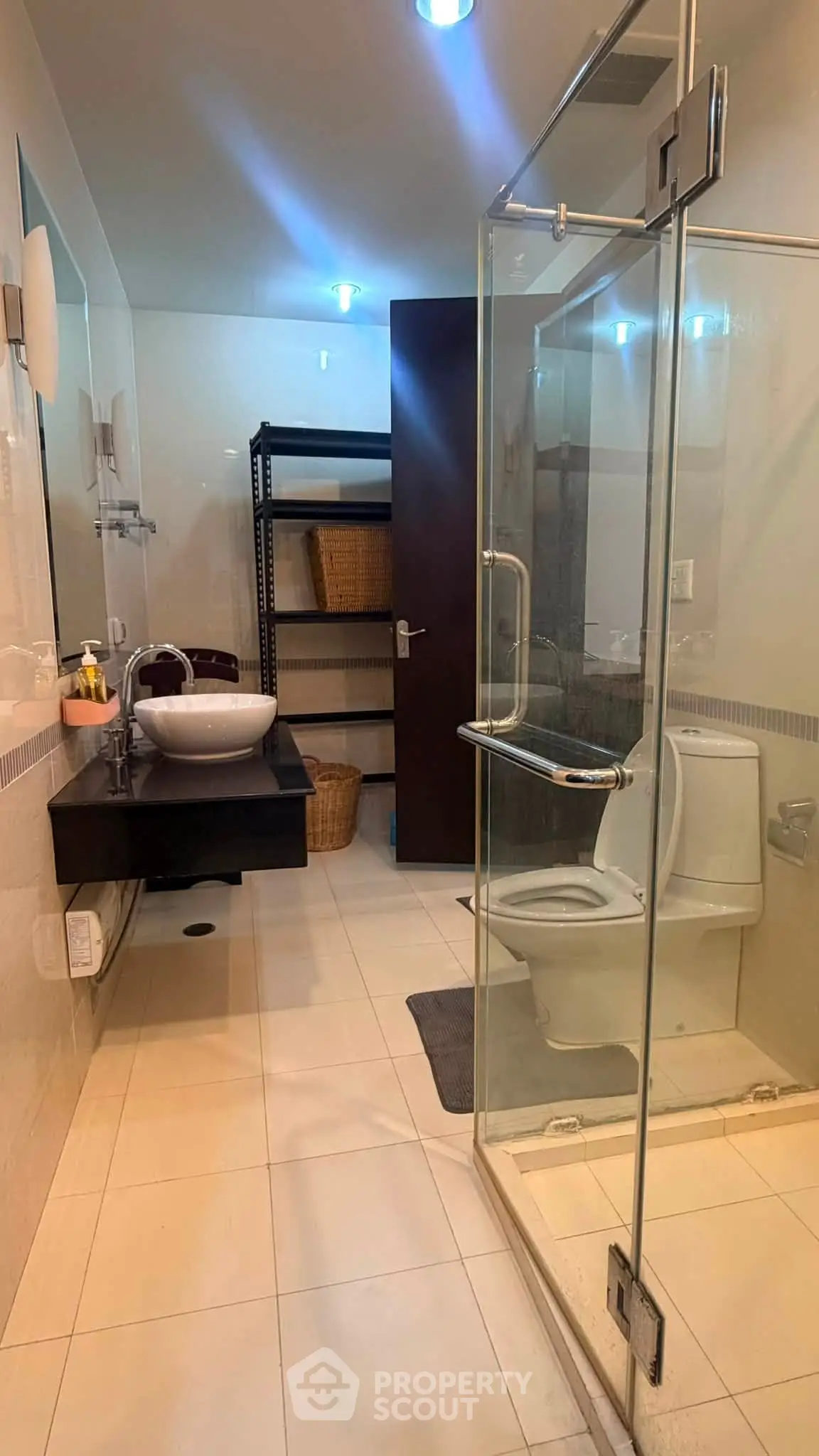 Modern bathroom with glass shower and sleek vanity in contemporary home.