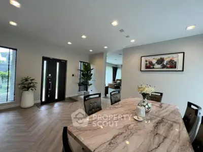 Elegant dining area with marble table and modern decor in a spacious open-plan home.