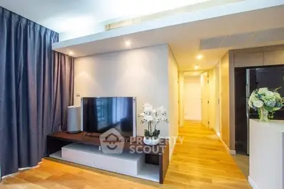 Modern living room with sleek TV setup and elegant decor in a bright apartment.