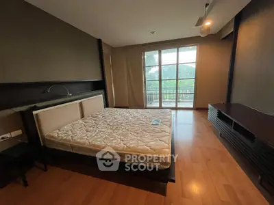 Spacious bedroom with large window and wooden flooring
