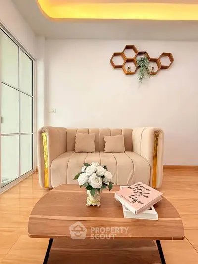 Stylish living room with modern beige sofa, wooden coffee table, and decorative wall art.