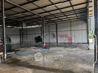 Spacious industrial warehouse with metal walls and open layout, ideal for storage or workshop use.