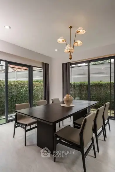 Elegant dining room with modern chandelier and garden view, perfect for family gatherings.
