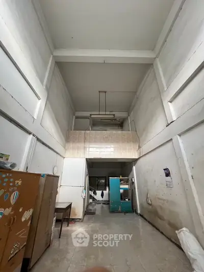 Spacious industrial-style room with high ceilings and minimalist decor