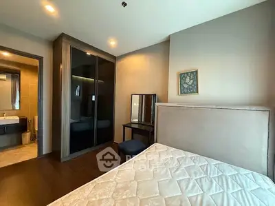 Modern bedroom with elegant decor and ensuite bathroom in luxury apartment.