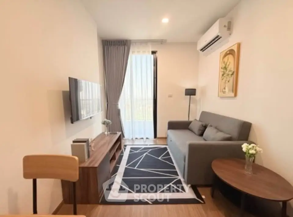 Modern living room with stylish decor, featuring a sleek sofa, wall-mounted TV, and elegant furnishings.