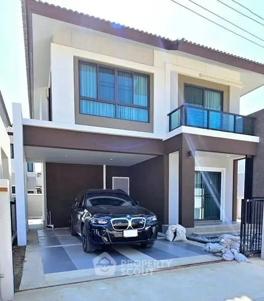 Modern two-story house with carport and sleek black car parked in driveway.