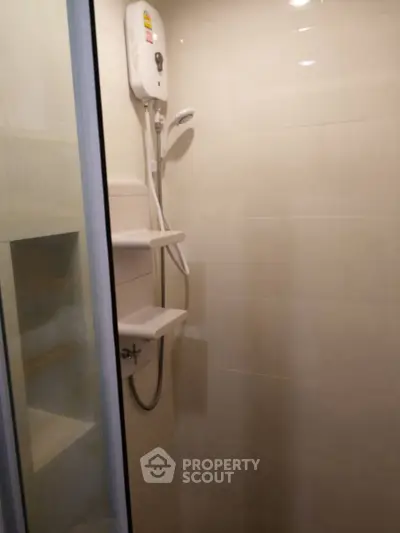 Modern bathroom shower area with sleek design and water heater installation.