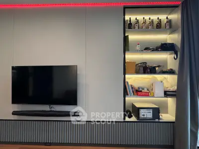 Modern living room with wall-mounted TV and illuminated shelving unit.