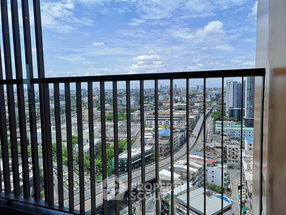 Stunning cityscape view from a high-rise balcony with clear blue skies.