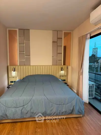 Modern bedroom with stylish decor and large window offering city view