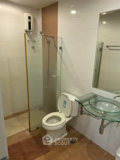 Modern bathroom with glass shower and stylish sink in real estate property