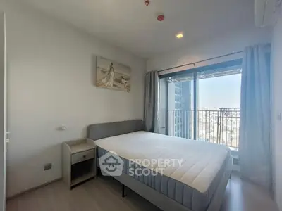 Modern bedroom with balcony and city view in high-rise apartment