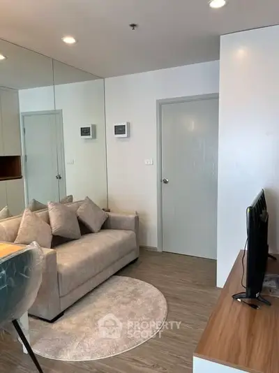 Modern living room with cozy sofa and sleek TV setup in stylish apartment.