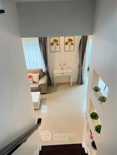 Modern living room with elegant decor and natural light from large windows.