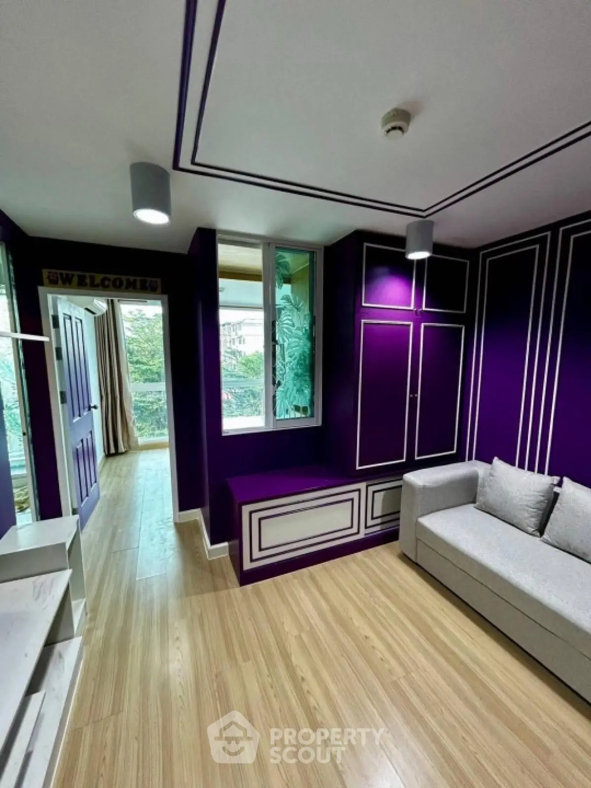 Stylish modern living room with vibrant purple accents and cozy seating area