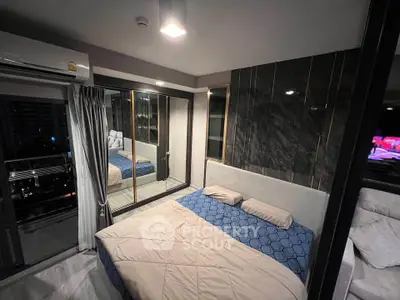 Modern bedroom with stylish decor and large mirrored wardrobe in a high-rise apartment.