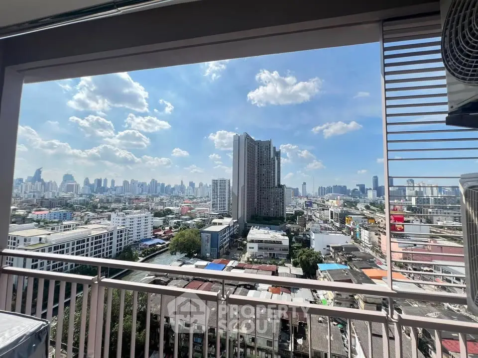 Stunning cityscape view from a high-rise balcony with clear blue skies and urban skyline.