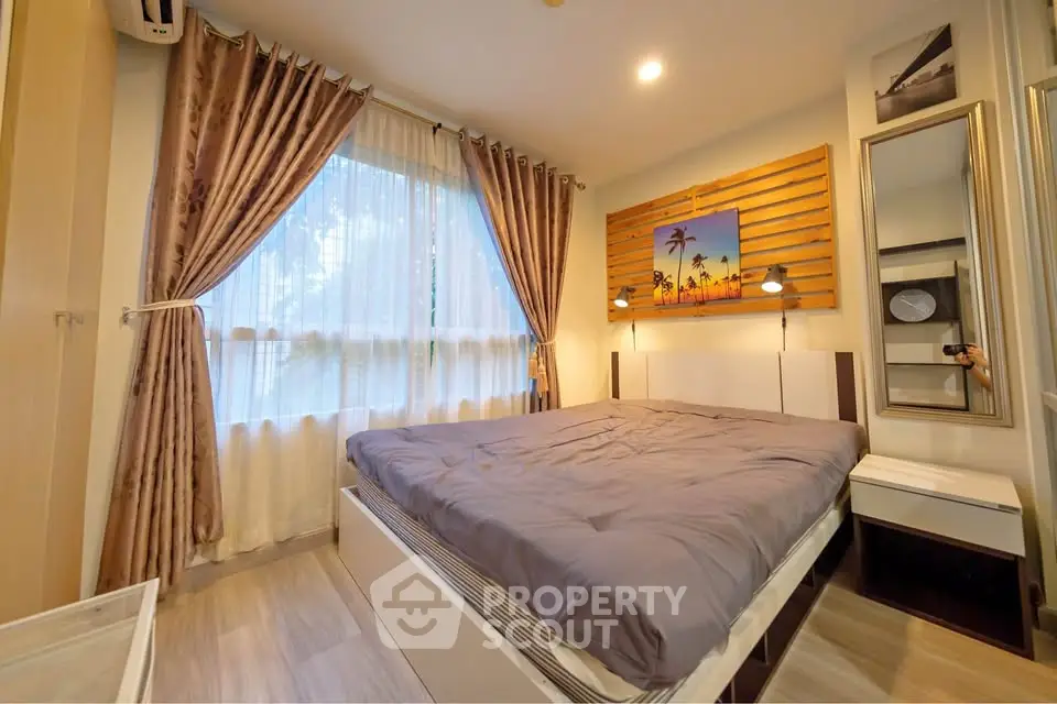 Cozy bedroom with elegant decor and large window for natural light.