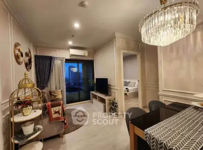 Elegant living room with modern decor and dining area, featuring a stylish chandelier and cozy ambiance.