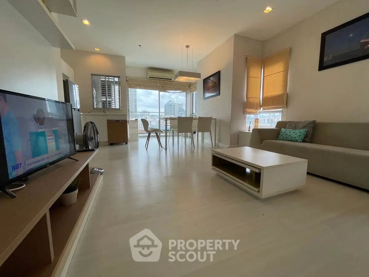 Spacious modern living room with city view, stylish furniture, and natural light.
