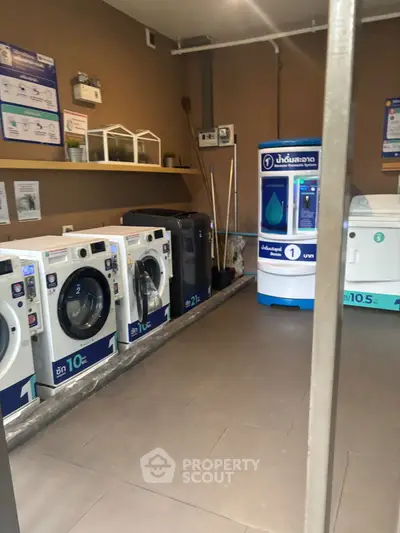 Modern laundry room with multiple washing machines and water dispenser