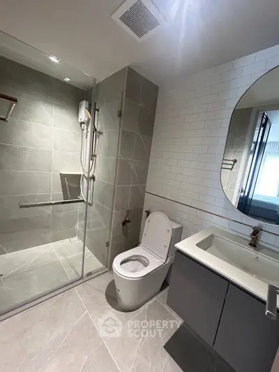 Modern bathroom with sleek shower, stylish vanity, and contemporary toilet design.