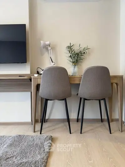 Modern study area with stylish chairs and desk in a cozy apartment setting.
