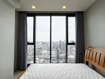Stunning bedroom with panoramic city view from floor-to-ceiling windows