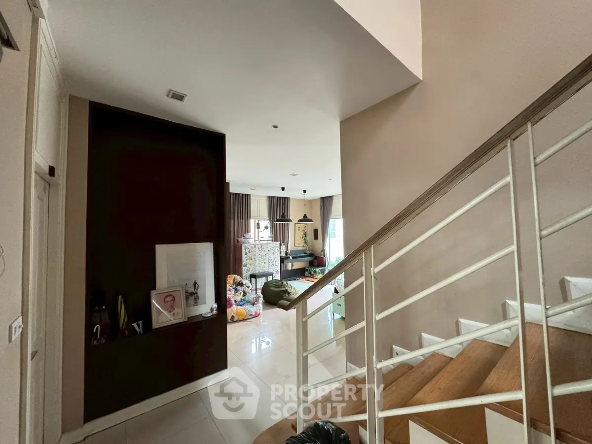 Spacious living area with modern staircase and natural light