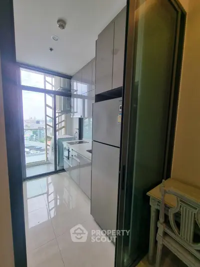 Modern kitchen with sleek cabinets and large window offering city view