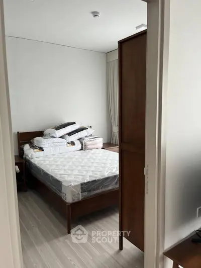 Cozy bedroom with wooden furniture and natural light, perfect for restful nights.