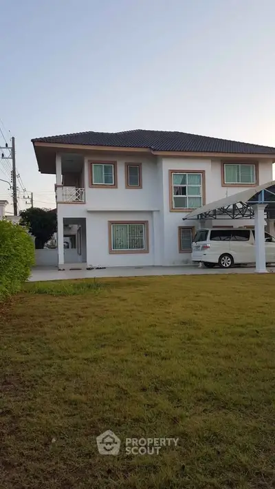 Charming two-story house with spacious lawn and carport in a serene neighborhood.