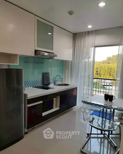 Modern kitchen with sleek appliances and balcony view in a stylish apartment.