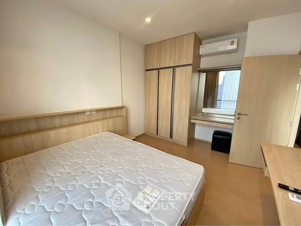 Modern bedroom with wooden furniture and built-in wardrobe in a cozy apartment.