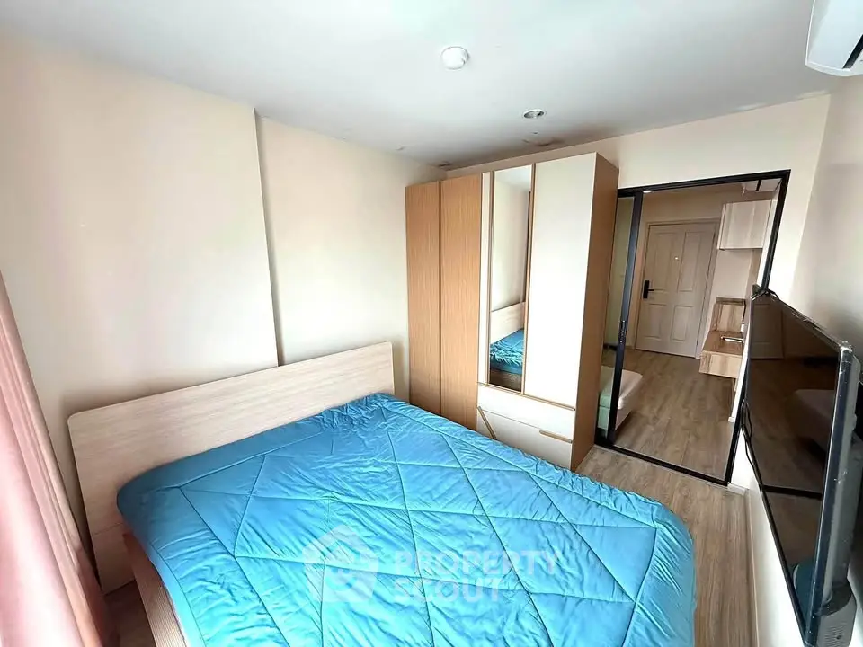Cozy bedroom with modern furnishings and ample natural light, featuring a comfortable bed and sleek wardrobe.