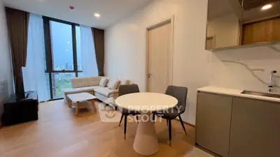 Modern living room with open kitchen, featuring stylish furniture and large windows with city view.