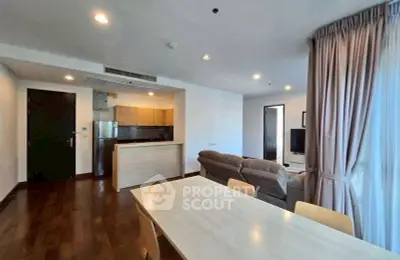Spacious open-plan living room with modern kitchen and dining area in a stylish apartment.