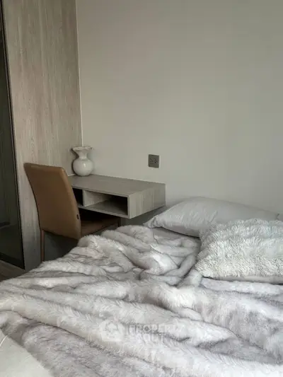 Cozy bedroom with plush bedding and modern desk, perfect for relaxation and productivity.