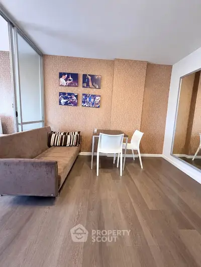 Modern living room with stylish decor and wooden flooring, featuring a cozy sofa and dining area.