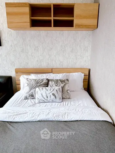 Cozy bedroom with stylish bedding and wooden shelves, perfect for relaxation.