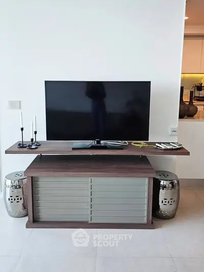 Modern living room with sleek TV stand and decorative elements, showcasing contemporary interior design.