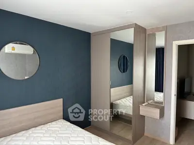 Modern bedroom with stylish mirror and wardrobe, featuring a comfortable mattress and sleek design.