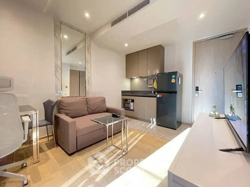 Modern living room with compact kitchen, featuring sleek appliances and stylish furniture in a cozy apartment.